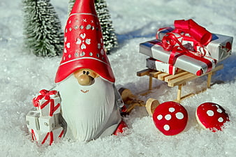 Christmas gnome with sled of gifts in snow