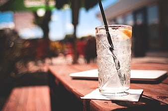 Refreshing Iced Drink with Lemon on Outdoor Wooden Table