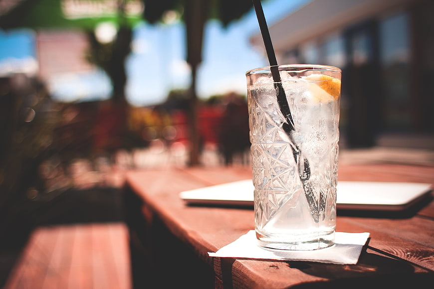 Refreshing Iced Drink with Lemon on Outdoor Wooden Table