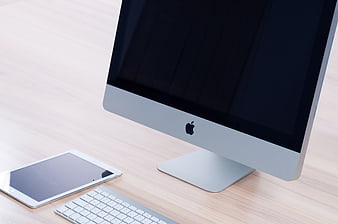 Modern Apple iMac Workspace with iPad and Keyboard on Desk