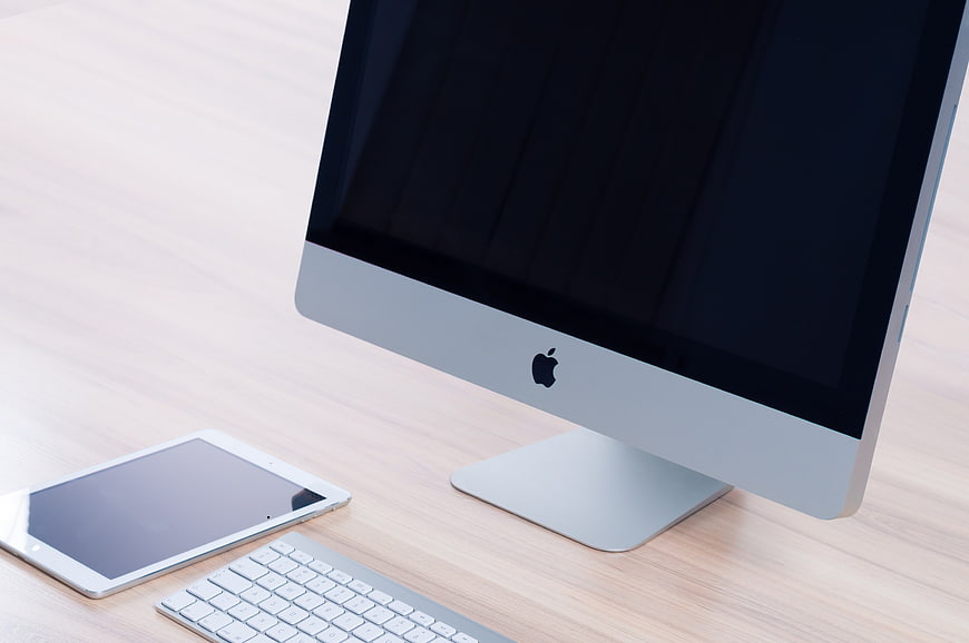 Modern Apple iMac Workspace with iPad and Keyboard on Desk