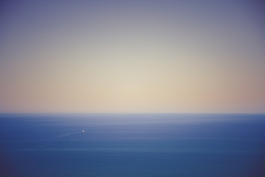 Minimalist Ocean Horizon with Distant Boat at Dusk