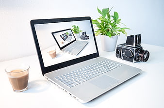 Laptop displaying recursive image with coffee and vintage camera