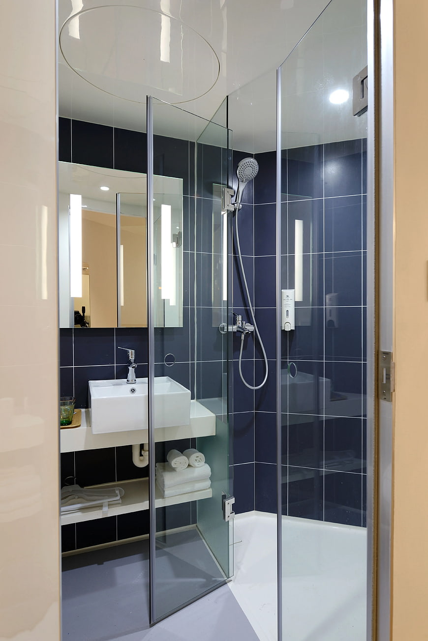 Modern Bathroom Interior with Blue Tiles and Glass Shower