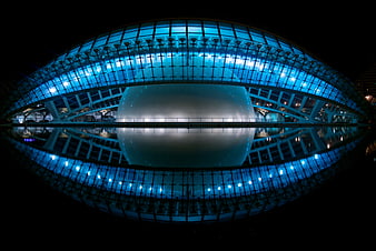 Modern Blue Glass Architecture with Water Reflection at Night