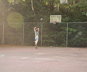 Boy Jumping to Shoot Basketball on Outdoor Court