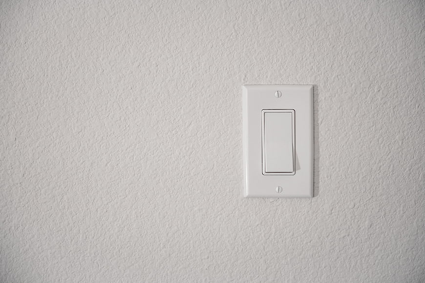 White Rocker Light Switch on Textured Wall
