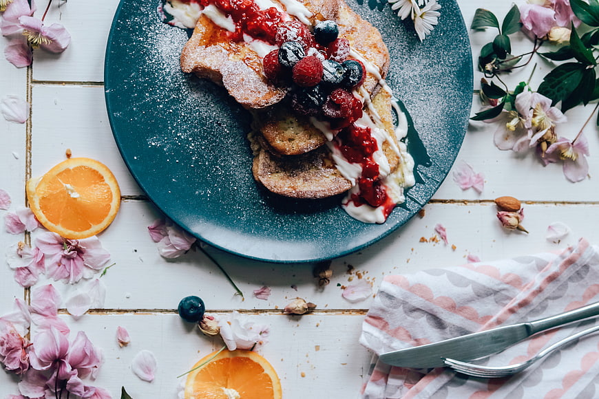 Overhead view of French toast with berries and flowers