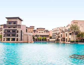 Luxury waterfront villas with turquoise pool and palm trees