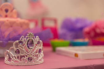 Silver tiara with purple gems on pink party table