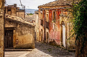 Historic Cobblestone Alleyway In Old Sicilian Village With Weathered Buildings