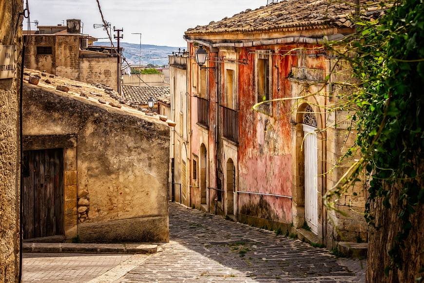 Historic Cobblestone Alleyway In Old Sicilian Village With Weathered Buildings