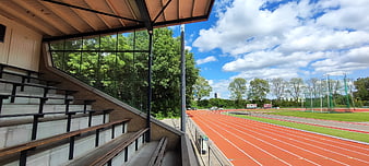 Empty stadium bleachers overlooking red running track