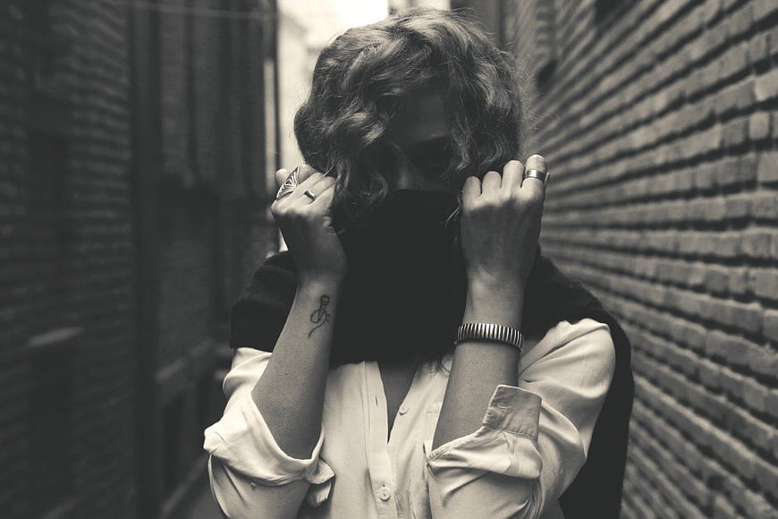 Woman Hiding Face in Alley Grayscale Portrait