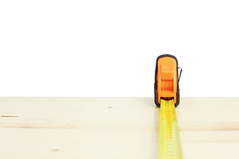 Orange Tape Measure on Wooden Surface with White Background