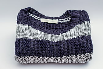 Folded Navy and Grey Knit Sweater on White Background