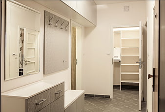 Modern minimalist entryway with white storage and coat rack