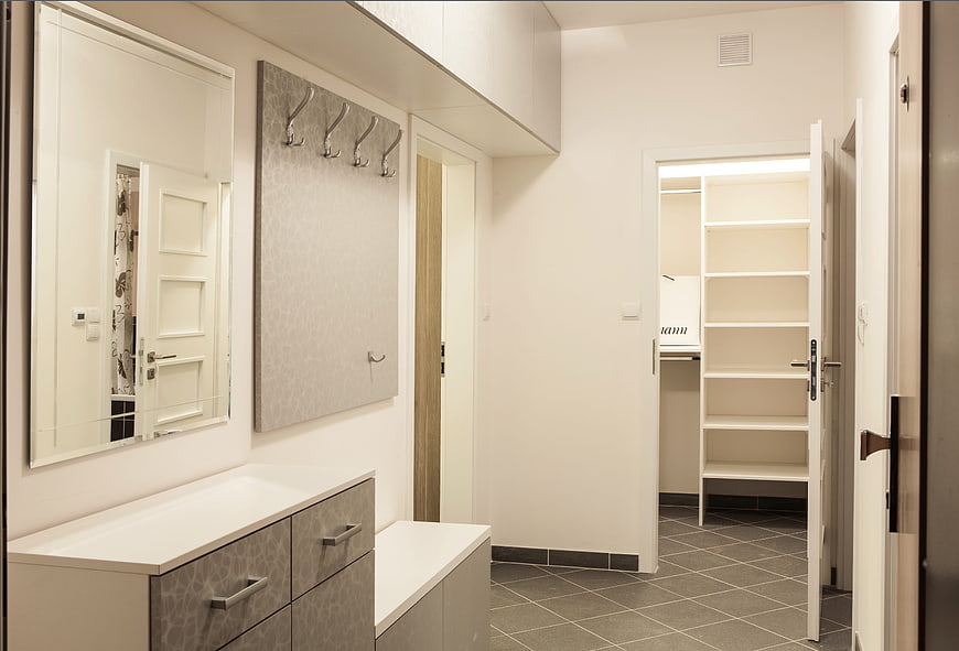 Modern minimalist entryway with white storage and coat rack