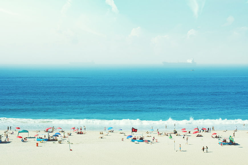 Wide Beach Scene with Blue Ocean and Summer Tourists