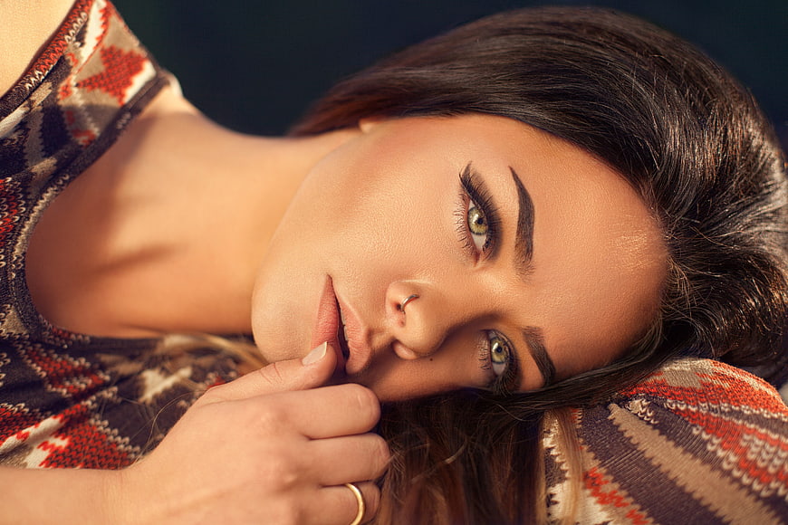 Close-up portrait of a beautiful brunette woman lying down