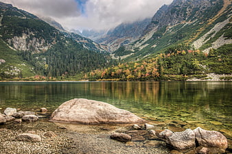 Serene Mountain Lake Landscape With Rocky Shore And Autumn Foliage