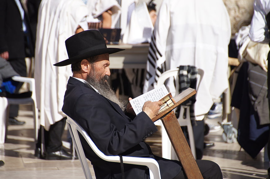 Orthodox Jewish man reading prayer book in Jerusalem