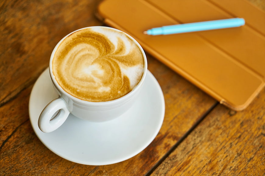 Latte Art Coffee Cup with Tablet on Wooden Table
