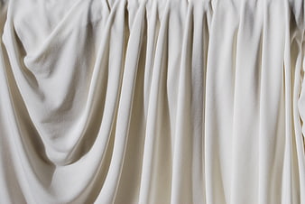 Close-up of draped cream fabric with soft folds and texture