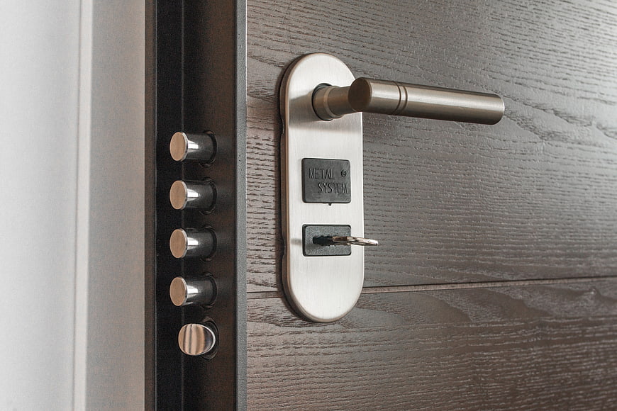 Close-up of modern metal door handle with key in lock