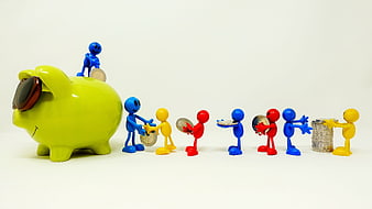 Colorful figurines saving coins in a green piggy bank