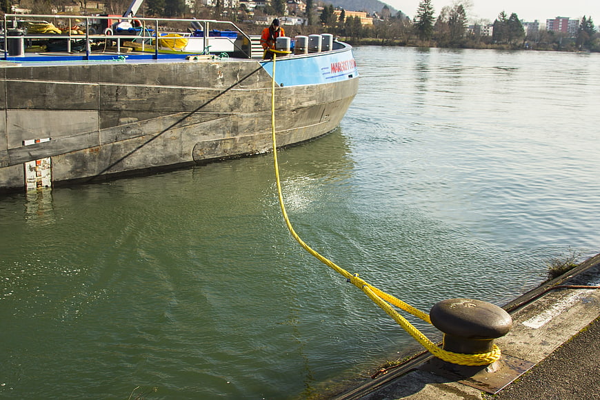 Cargo ship moored at river dock with yellow rope