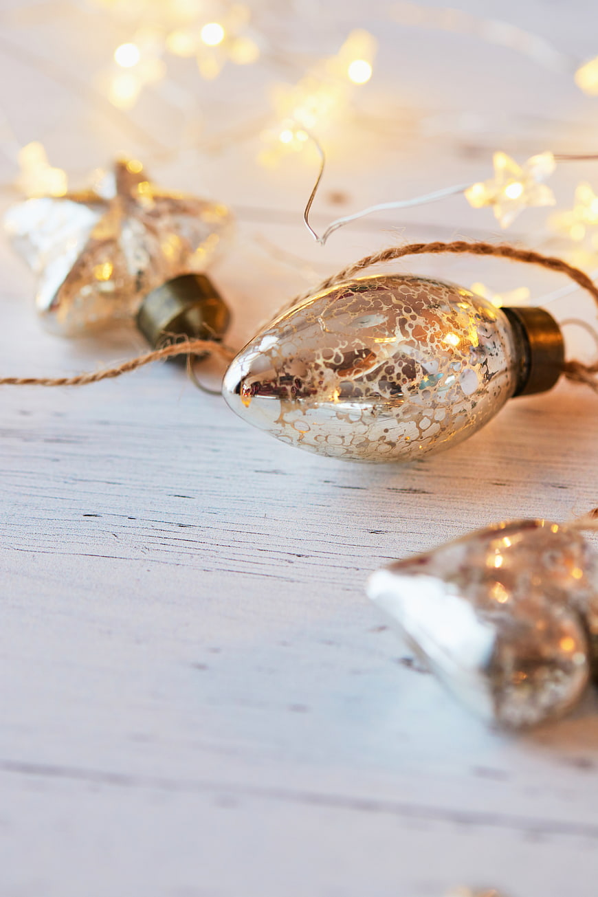 Vintage Christmas Ornaments with Fairy Lights on White Wood