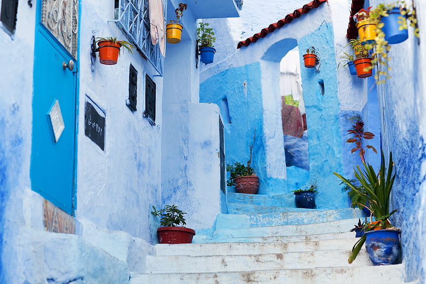 Blue alleyway in Chefchaouen, Morocco with potted plants