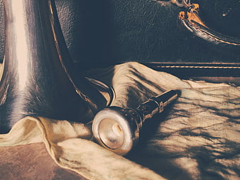 Close-up of silver trumpet mouthpiece on beige cloth