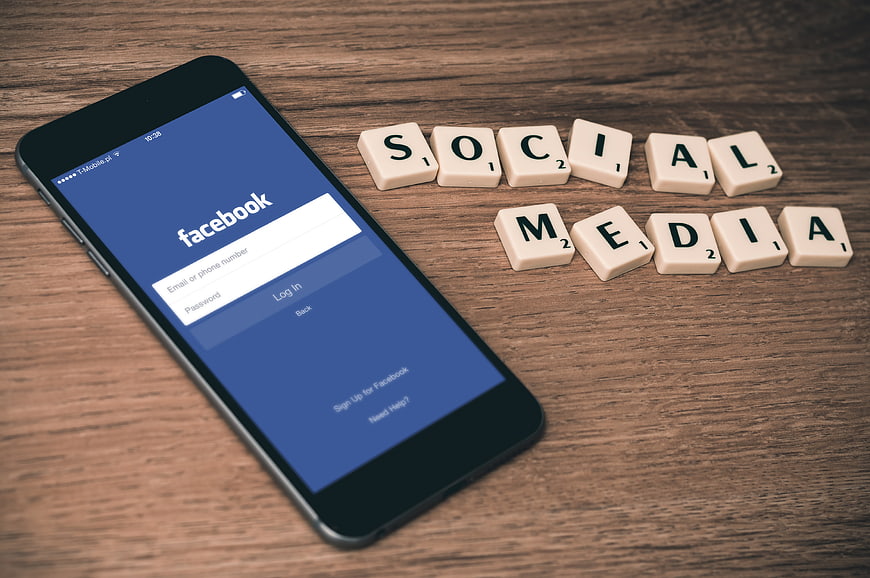 Smartphone with Facebook login screen and social media Scrabble tiles