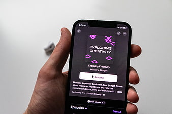 Hand Holding Smartphone Displaying Podcast App Interface