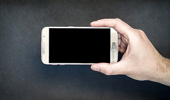 Hand Holding Smartphone With Black Screen On Dark Background