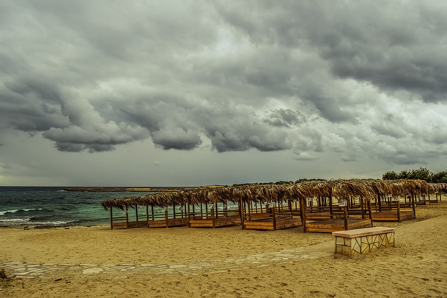 Empty Beach Cabanas Under Dramatic Stormy Clouds
