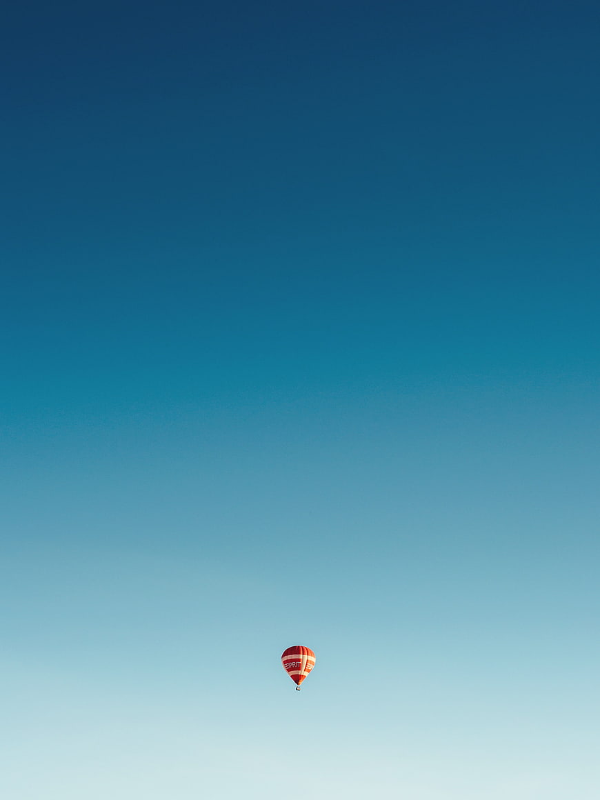 Minimalist Red Hot Air Balloon Against Gradient Blue Sky