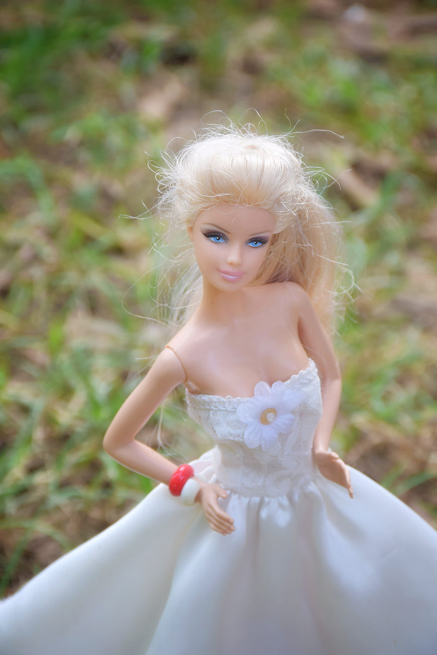 Blonde doll in white wedding dress with messy hair