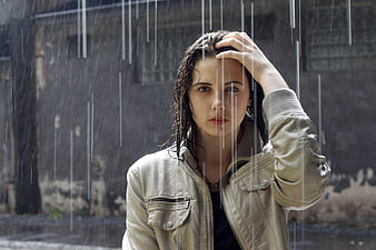 Portrait of a young woman standing in heavy rain