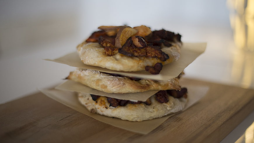 Stack of savory flatbread sandwiches with roasted vegetables