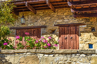 Traditional Stone House with Wooden Shutters and Pink Flowers