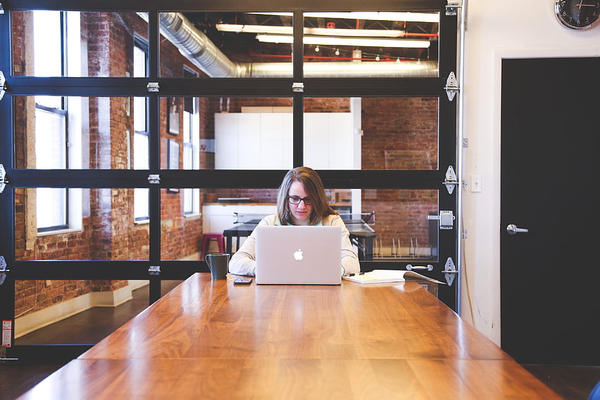 Woman working on laptop in modern industrial office