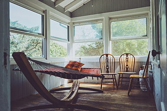 Cozy Sunlit Porch with Hammock and Wooden Chairs