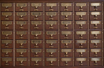 Vintage wooden card catalog drawers with brass labels