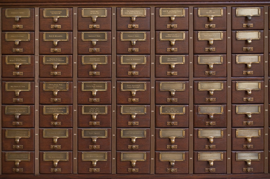 Vintage wooden card catalog drawers with brass labels