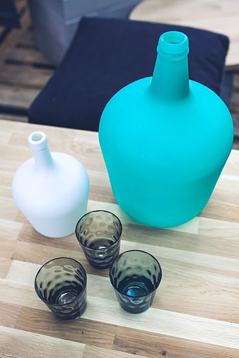 Colorful Glass Bottles and Textured Tumblers on Wooden Table