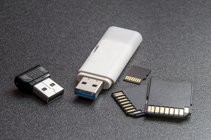 USB flash drives and SD memory cards on dark textured background
