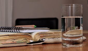 Glass of water next to open book and study notes
